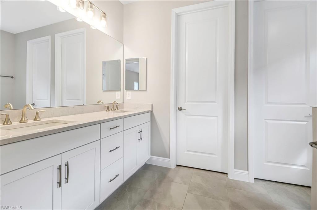 4652 Centaurus Circle Naples, FL 34120 - Photo 16 of 45 Bathroom featuring double vanity and light tile patterned floors