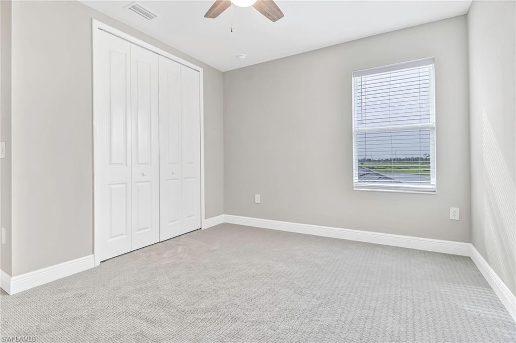 4652 Centaurus Circle Naples, FL 34120 - Photo 26 of 45 Unfurnished bedroom featuring light carpet, a closet, and a ceiling fan