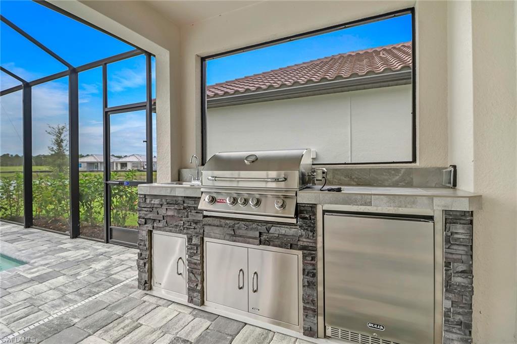 4652 Centaurus Circle Naples, FL 34120 - Photo 27 of 45 View of patio / terrace featuring glass enclosure, area for grilling, an outdoor pool, a sunroom, and a residential view