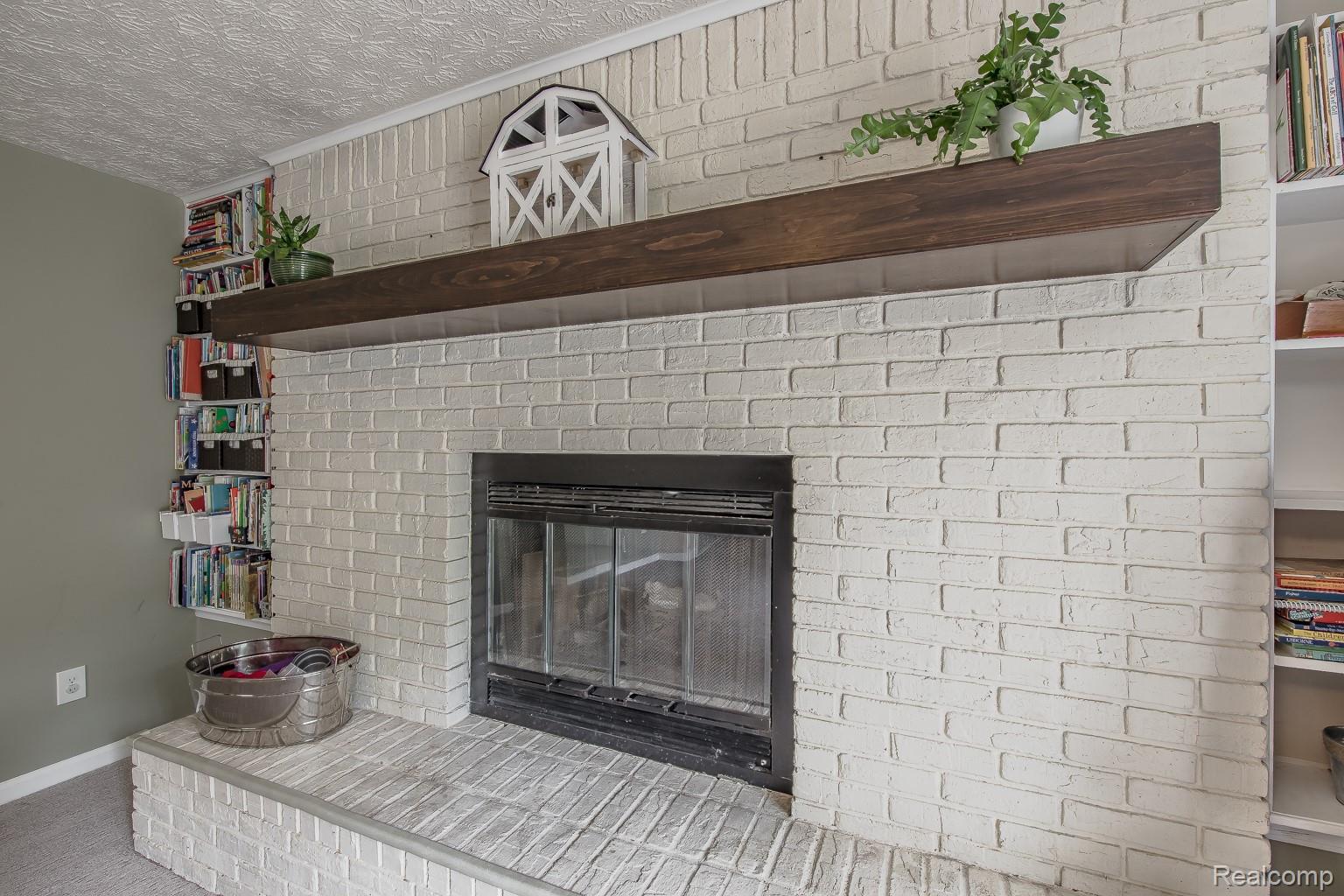 9618 Ridge Top Trail Clarkston, MI 48348 - Photo 22 of 32 Natural fireplace flanked by built-in shelving on both sides