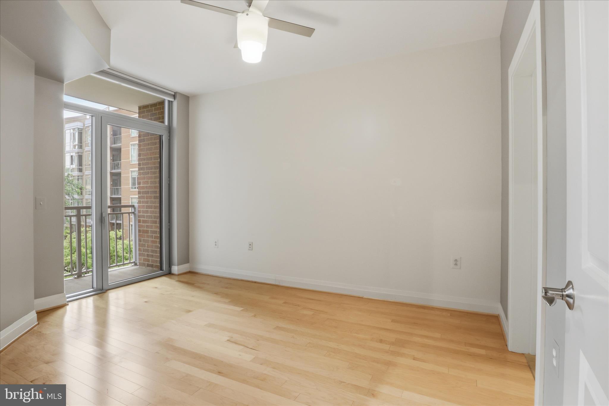 11990 Market Street, Unit 216 Reston, VA 20190 - Photo 26 of 41 a view of an empty room with wooden floor and a window