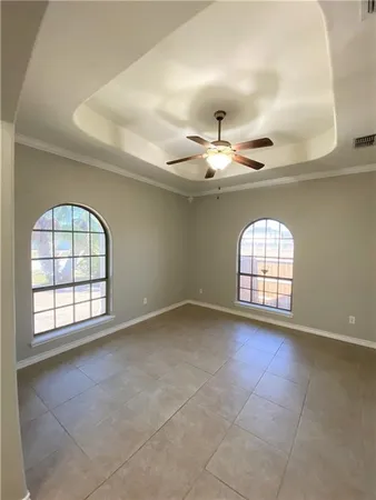 an empty room with windows and fan