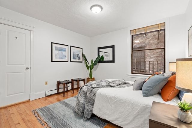 a bedroom with a bed and wooden floor