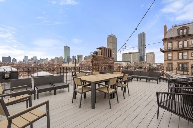 a terrace with wooden floor table and chairs