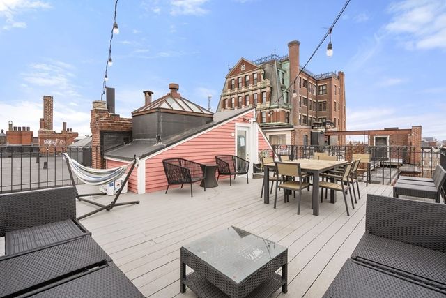 a roof deck with a table and chairs