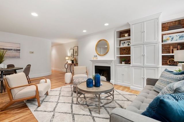 a living room with furniture a rug and a fireplace