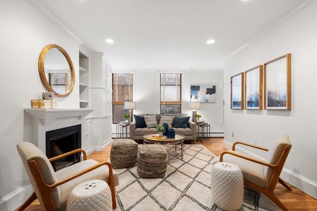 a living room with furniture a fireplace and a large window