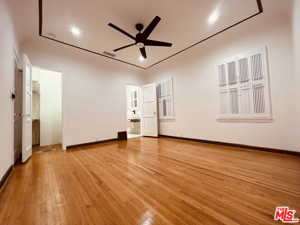 6187 Barrows Drive Los Angeles, CA 90048 - Photo 18 of 35 a view of empty room with wooden floor and fan