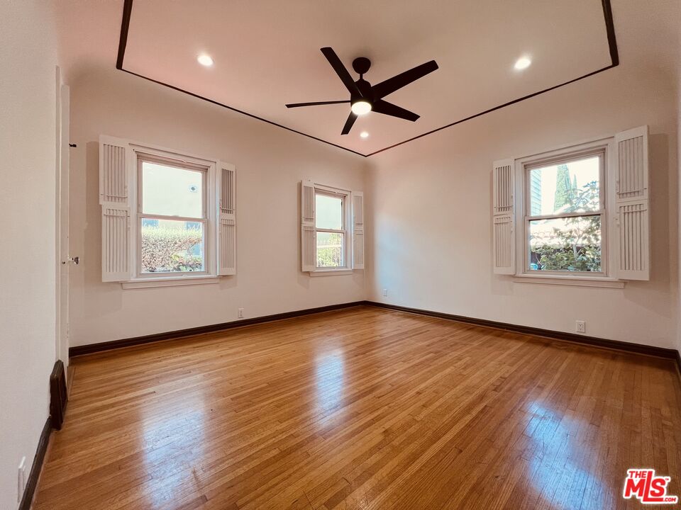 6187 Barrows Drive Los Angeles, CA 90048 - Photo 19 of 35 a view of an empty room with wooden floor and a window