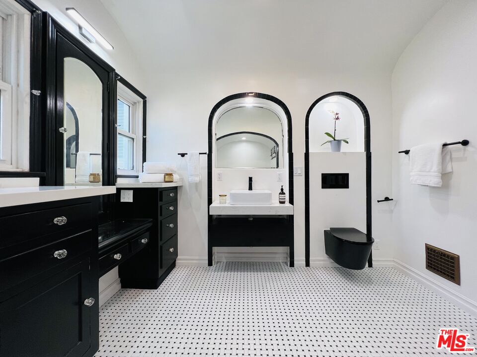 6187 Barrows Drive Los Angeles, CA 90048 - Photo 25 of 35 a spacious bathroom with a double vanity sink a mirror and a bathtub
