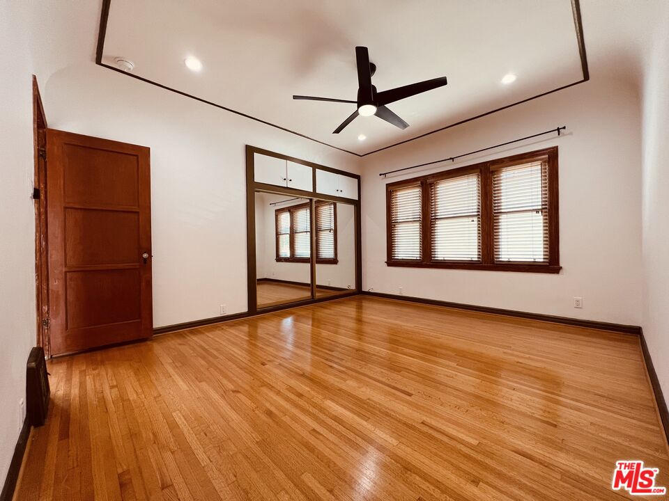 6187 Barrows Drive Los Angeles, CA 90048 - Photo 26 of 35 a view of empty room with wooden floor and fan