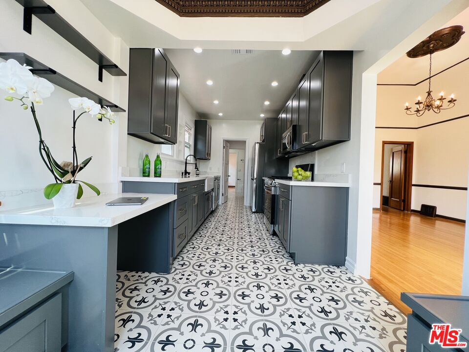 6187 Barrows Drive Los Angeles, CA 90048 - Photo 7 of 35 a kitchen with stainless steel appliances kitchen island sink refrigerator and stove