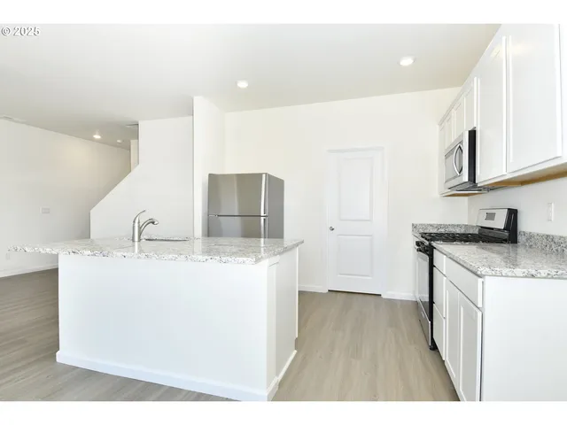 a kitchen with stainless steel appliances granite countertop a sink stove and cabinets