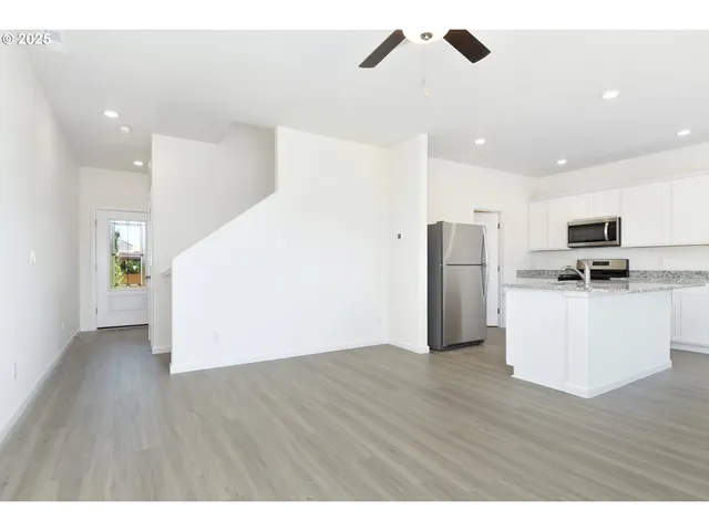 a view of kitchen with stainless steel appliances refrigerator stove microwave and cabinets