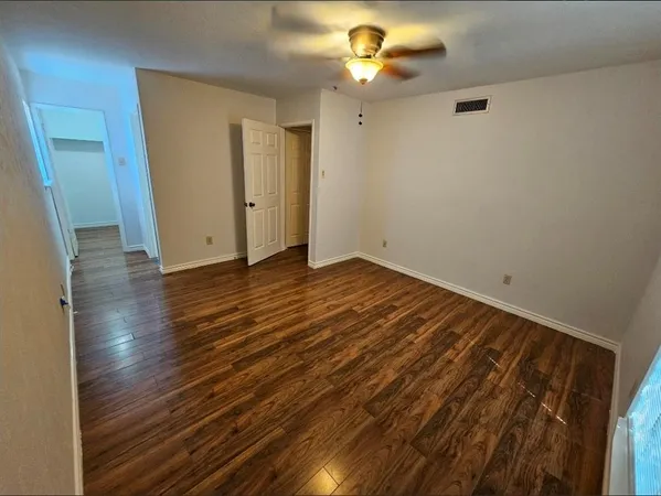 a view of a hallway with wooden floor and staircase