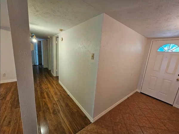 a view of a room with kitchen island microwave and wooden floor