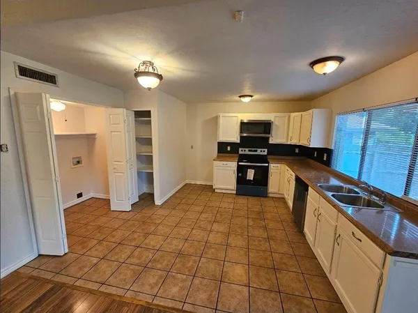 a kitchen with a sink a counter top space cabinets and stainless steel appliances