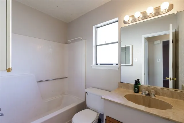 a bathroom with a sink toilet a mirror and shower