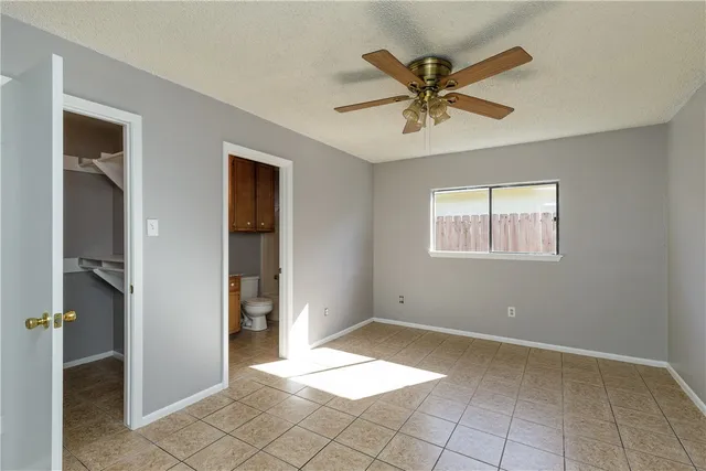 a view of an empty room with a ceiling fan