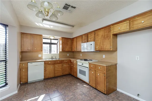 a kitchen with a stove a sink and cabinets