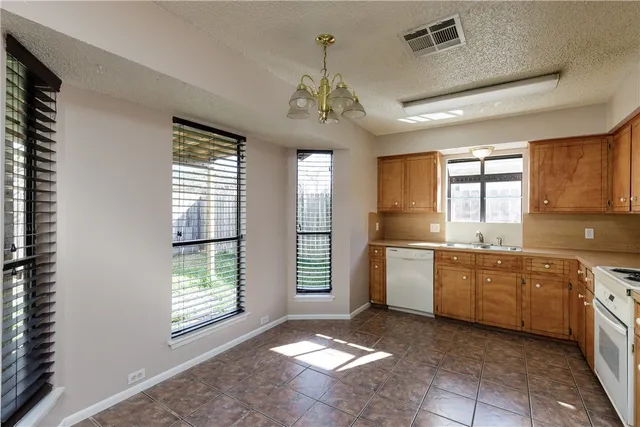 a kitchen with a sink chandelier and appliances