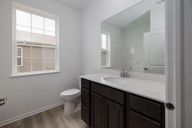 a bathroom with a sink a toilet and a window