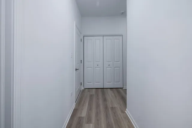 a view of a hallway with wooden floor