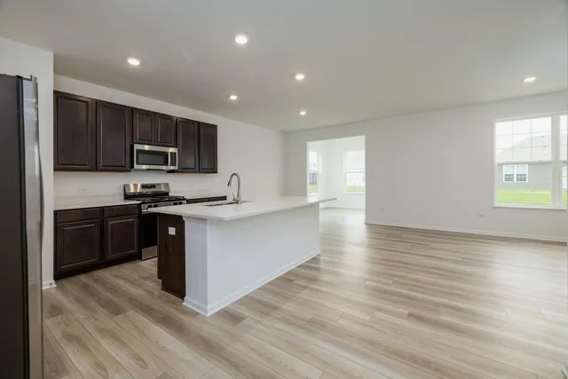 a kitchen with stainless steel appliances granite countertop a stove a sink and a refrigerator