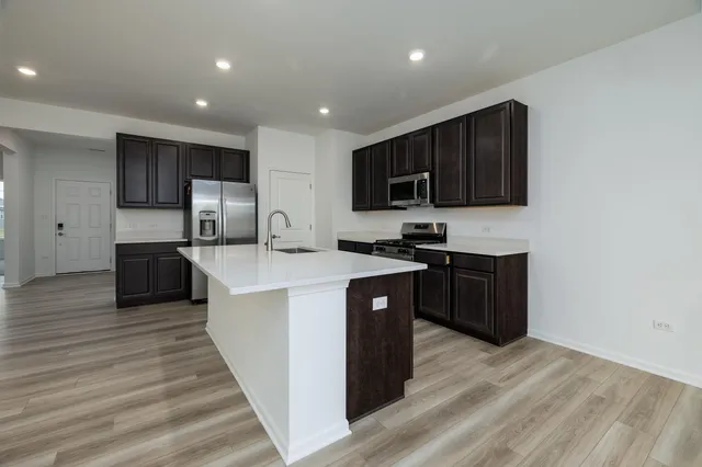 a kitchen with kitchen island granite countertop a sink and wooden cabinets