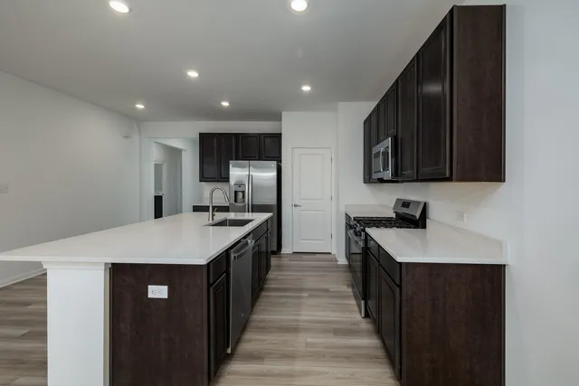 a kitchen with a sink stainless steel appliances a sink and cabinets