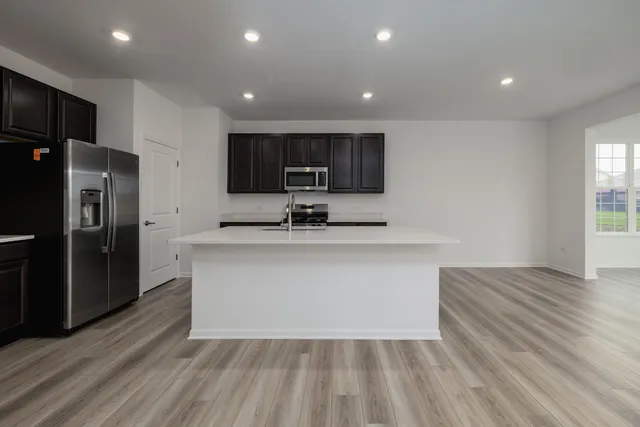 a view of kitchen with stainless steel appliances granite countertop a refrigerator a sink and a stove
