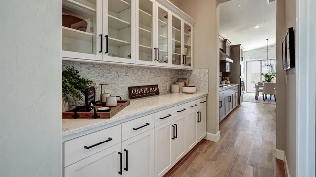 a kitchen with cabinets and wooden floor
