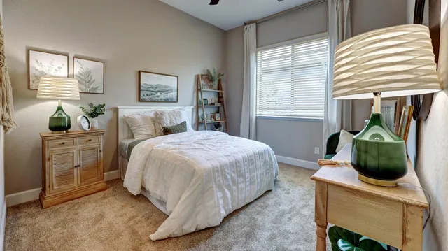 a bedroom with a bed a dresser and windows