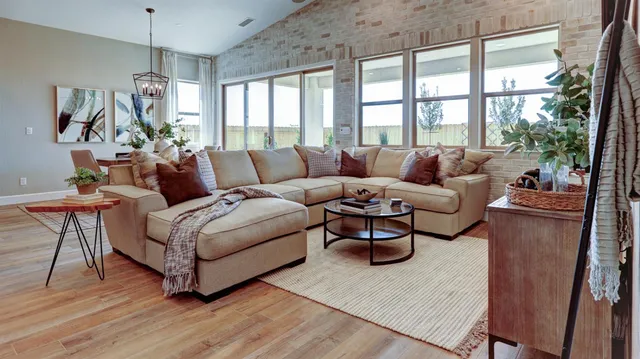 a living room with furniture a flat screen tv and a large window