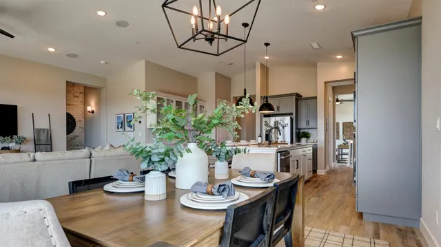 a view of a dining room and livingroom with furniture wooden floor a chandelier