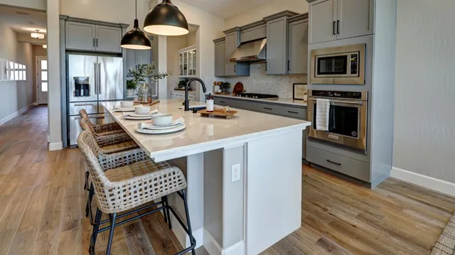 a view of kitchen with kitchen island stainless steel appliances refrigerator stove microwave and cabinets