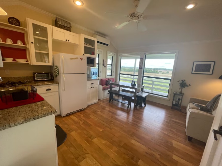 1281 Post Oak Point Road New Ulm, TX 78950 - Photo 17 of 29 An inviting open-concept living space features a functional kitchen and dining area with scenic outdoor views.