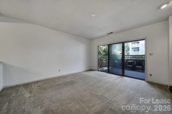 a view of an empty room with a fireplace and a window