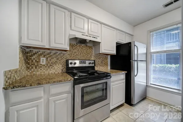 a kitchen with white cabinets and stainless steel appliances