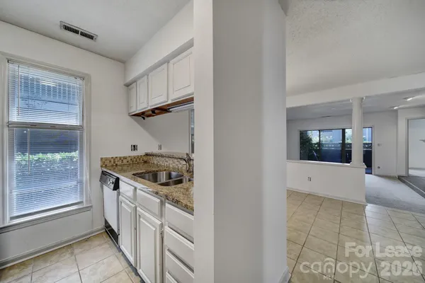 a kitchen with granite countertop a sink and a stove top oven