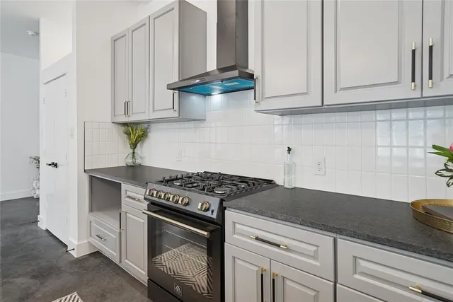a kitchen with granite countertop white cabinets and a stove