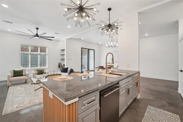 a kitchen with a stove a sink and chandelier