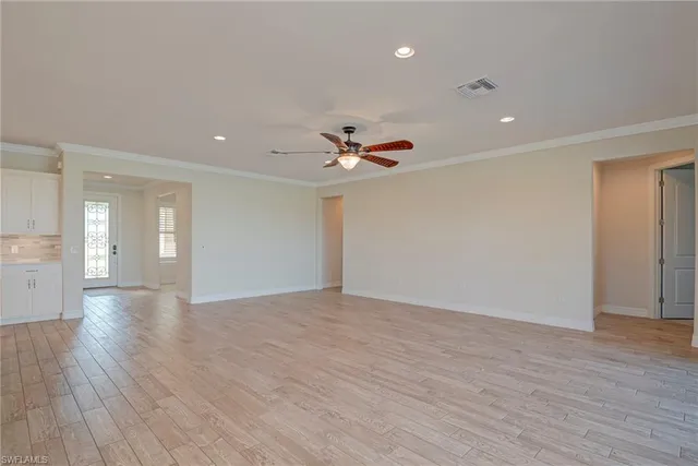 a view of an empty room and a ceiling fan window