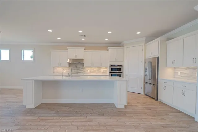 a kitchen with stainless steel appliances granite countertop a refrigerator and a stove top oven