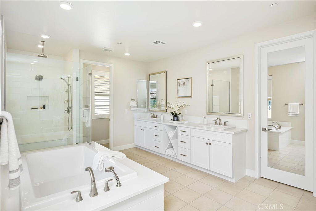 117 Swift Irvine, CA 92618 - Photo 38 of 62 a bathroom with a tub a sink shower and a mirror