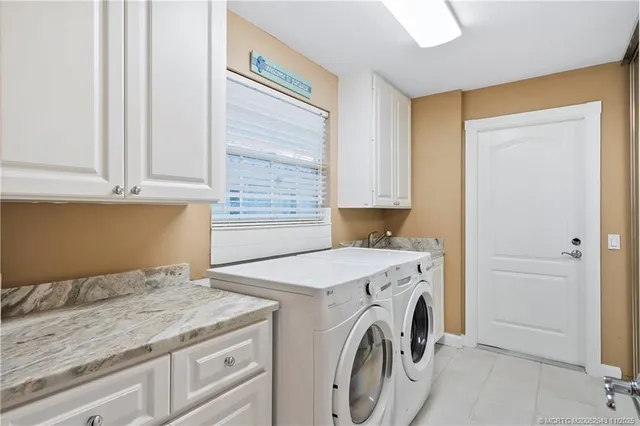 a utility room with granite countertop cabinets washer and dryer