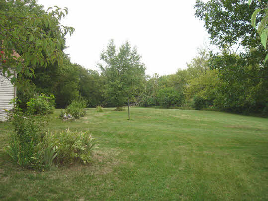 3452 Prairie Road Rockford, IL 61102 - Photo 2 of 6 a view of a green field with wooden fence
