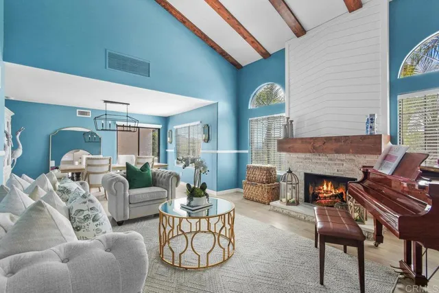 a living room with furniture a fireplace and a large window