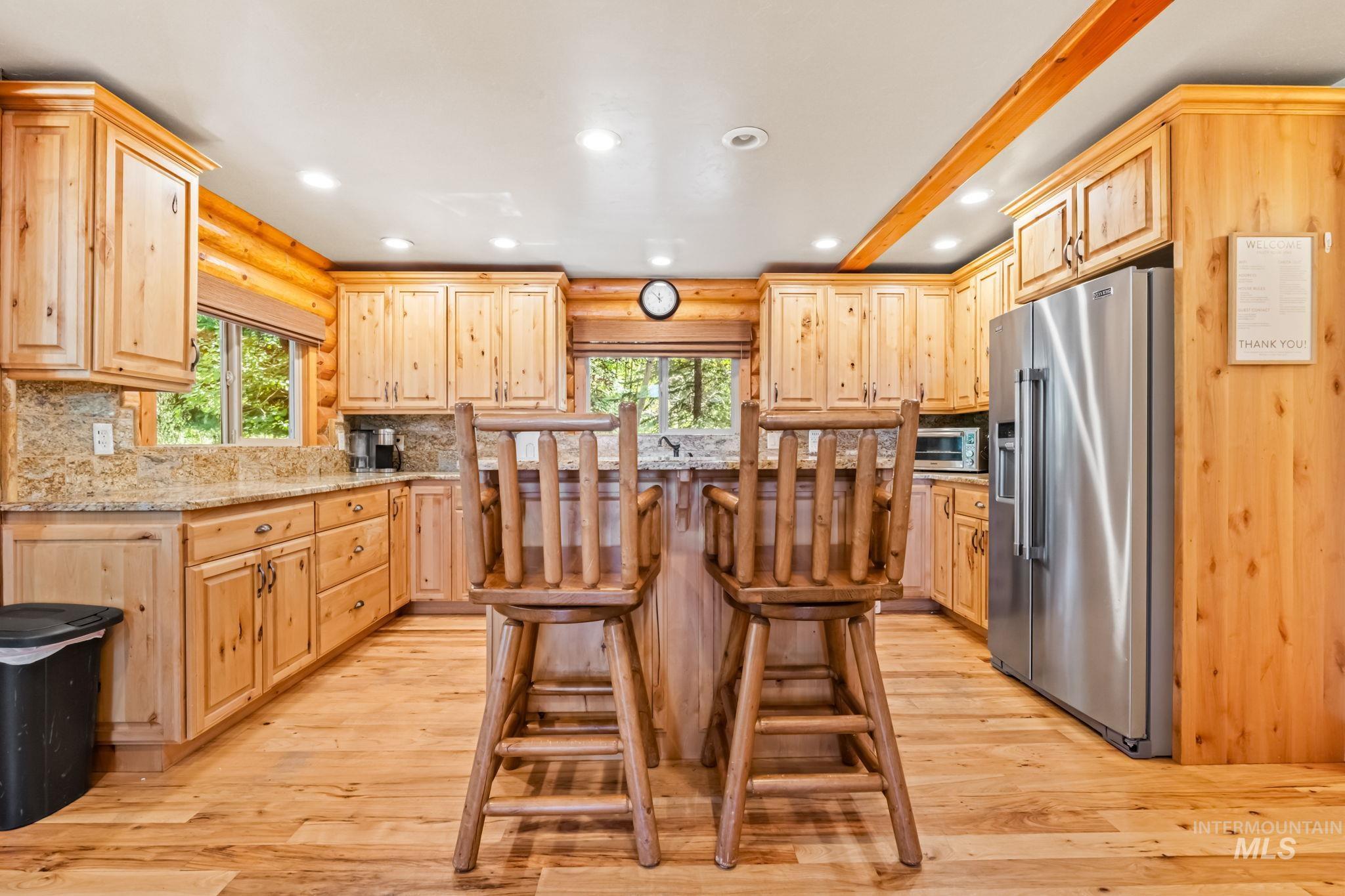 1160 Bell Flower Place McCall, ID 83638 - Photo 11 of 45 Kitchen with recessed lighting, a breakfast bar area, high end fridge, light brown cabinetry, and decorative backsplash