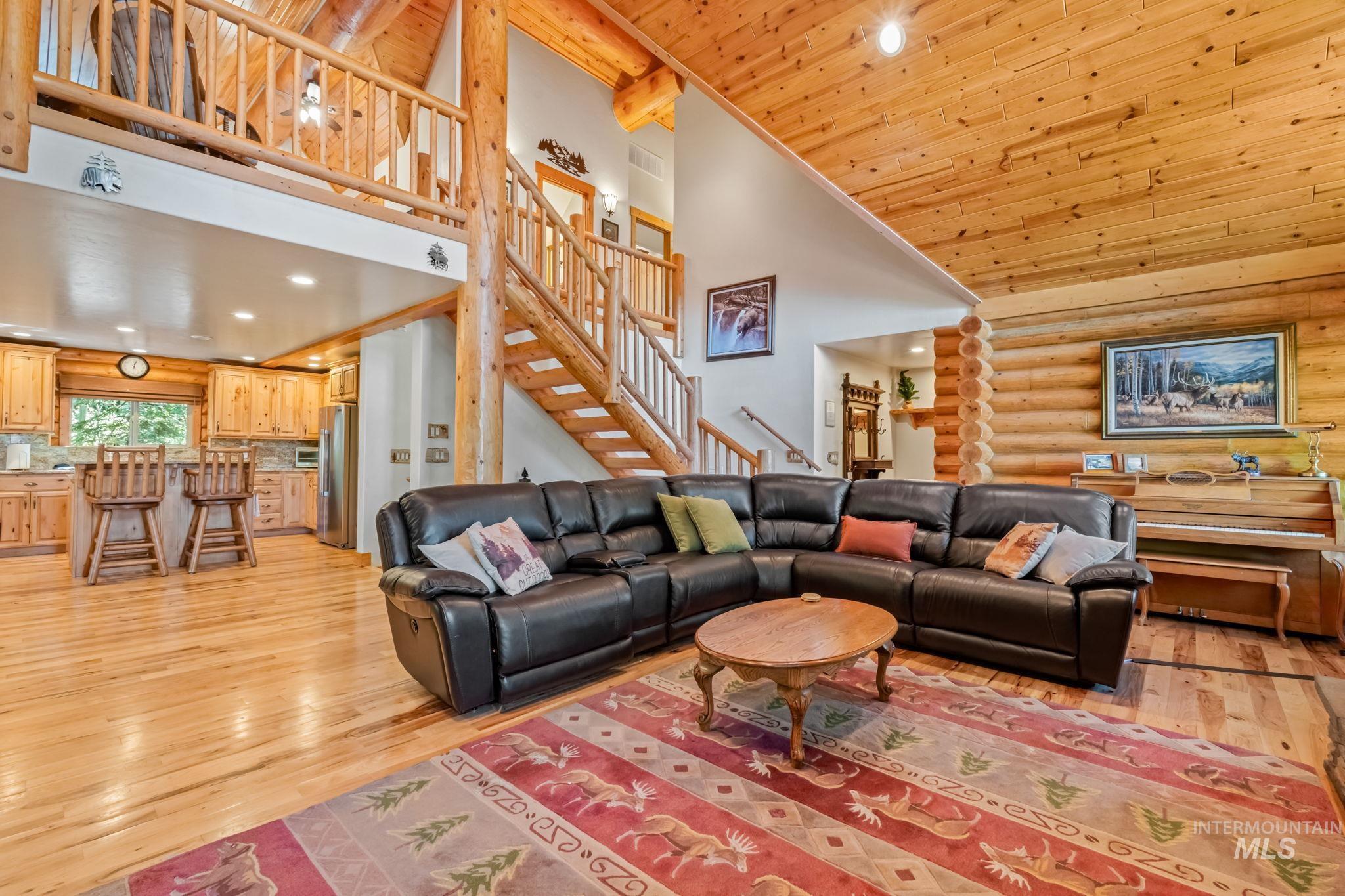 1160 Bell Flower Place McCall, ID 83638 - Photo 6 of 45 Living room featuring high vaulted ceiling, recessed lighting, stairs, light wood-style floors, and rustic walls